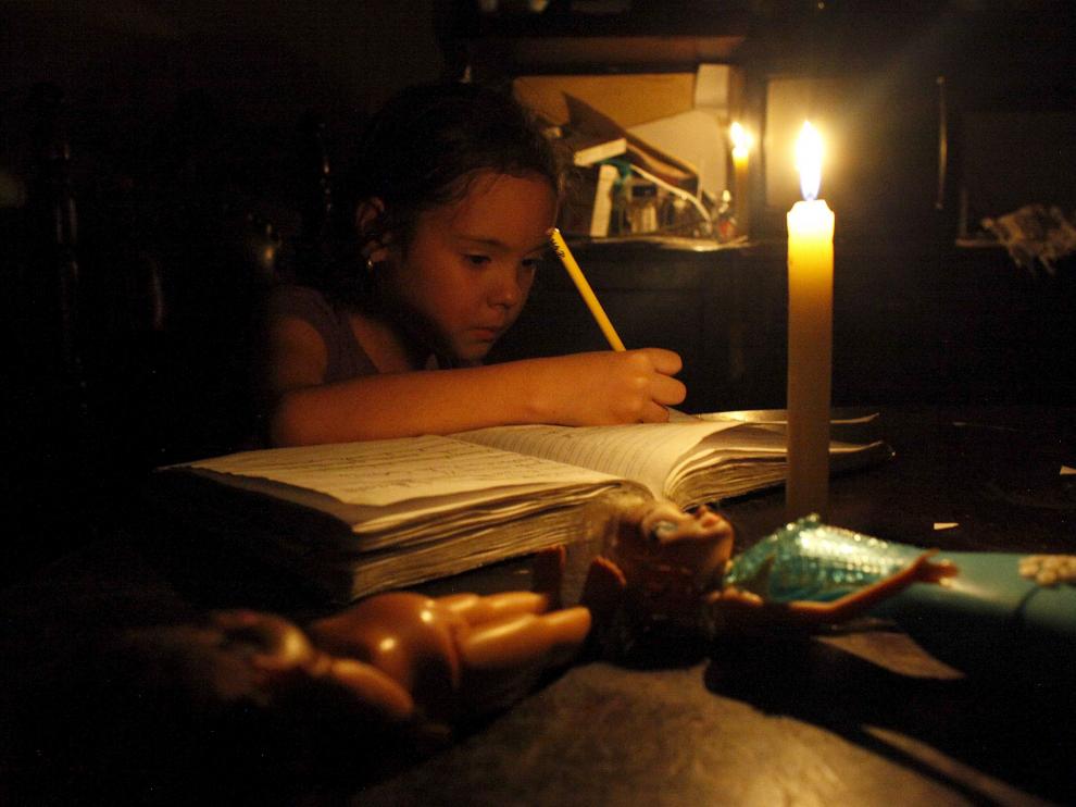 Una niña hace sus deberes con una vela encendida a causa de un corte de electricidad en San Cristóbal, en el estado de Tachira.