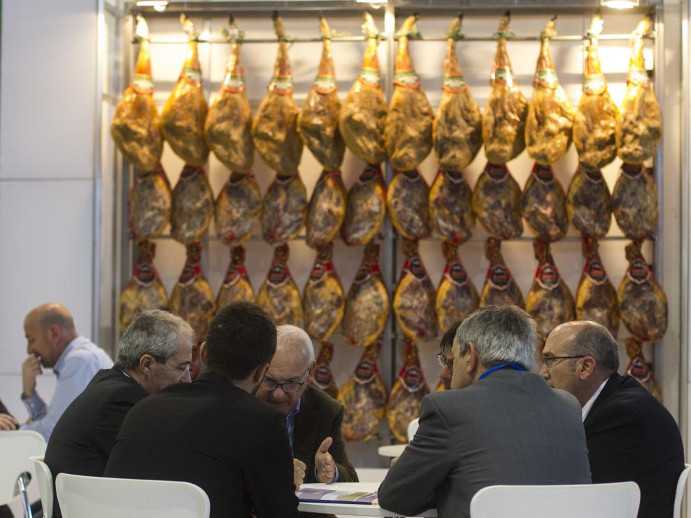 Unos visitantes reunidos en torno a una mesa en la segunda jornada de la Feria de Alimentaria.