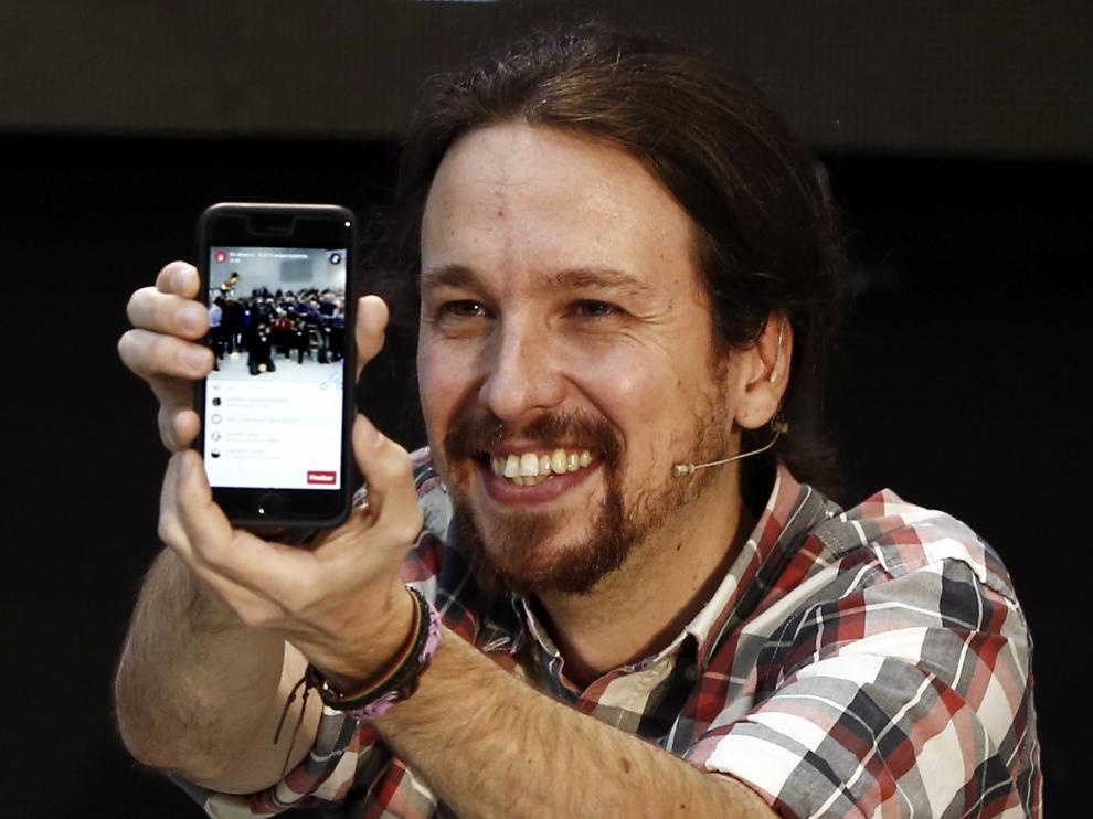 Pablo Iglesias (Podemos) muestra su móvil en un acto público.