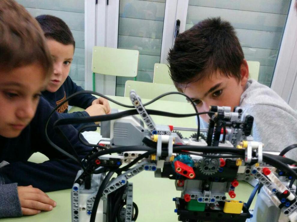 Unos niños disfrutan del taller de robótica en Huesca.