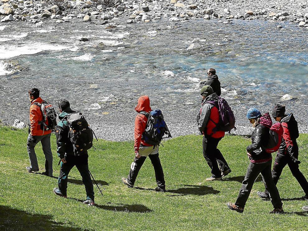 Un grupo de voluntarios, guiados por un forestal, inicia la búsqueda por las orillas del río.