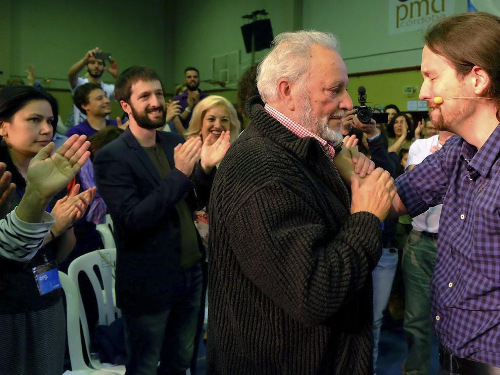 El secretario general de Podemos, Pablo Iglesias (d), se saluda con el exdirigente de IU, Julio Anguita