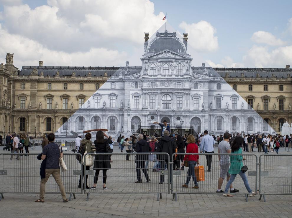 La enorme fotografía del francés JR cubre la pirámide del Louvre.