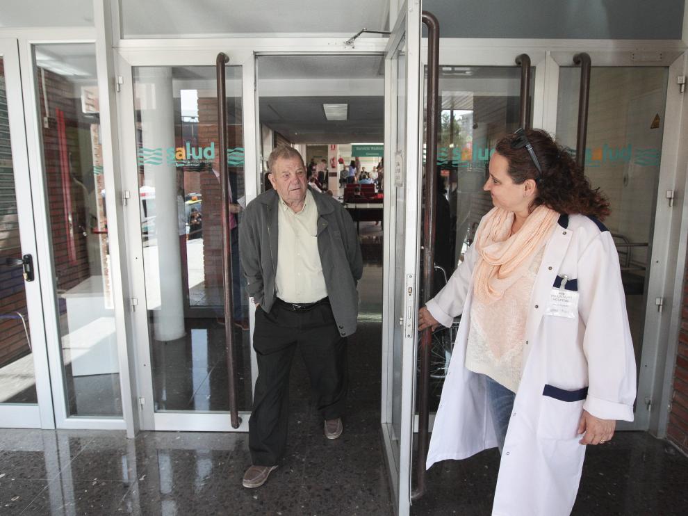 Una voluntaria abre la puerta del área de consultas externas del Obispo Polanco a un paciente.