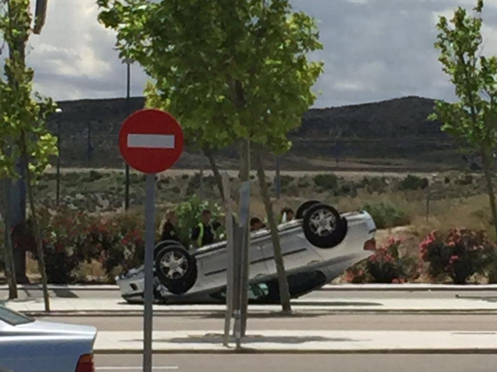 El coche que ha volcado este lunes en el parking de Puerto Venecia.
