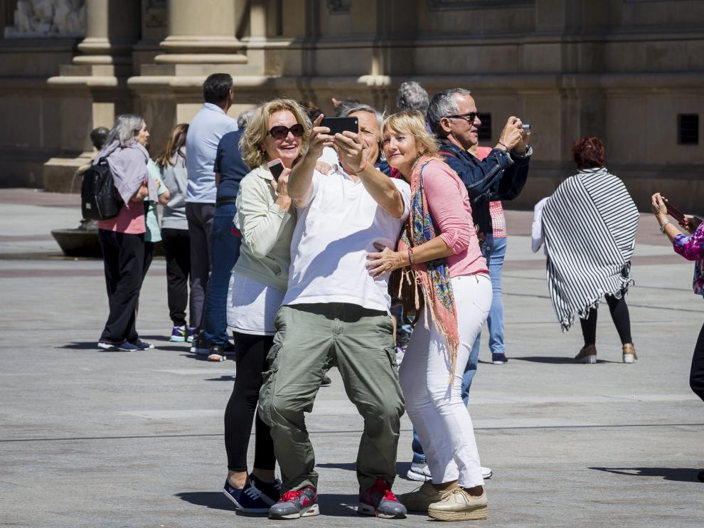 Unos turistas se fotografían en la plaza del Pilar.