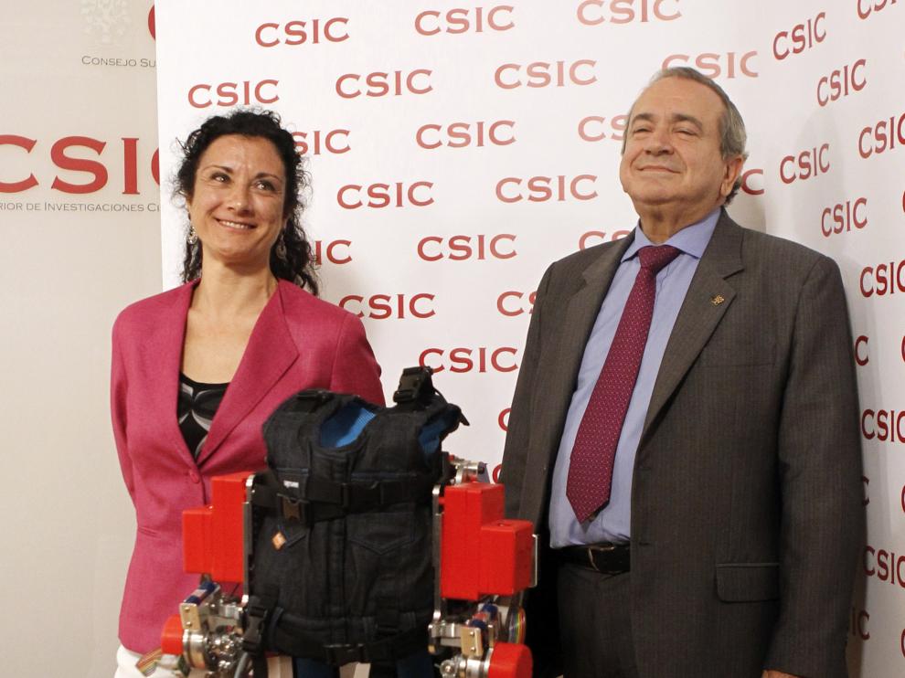 El presidente del CSIC, Emilio Lora, posa junto a la investigadora Elena García, que ha creado el exoesqueleto dirigido a niños con atrofia muscular espinal.