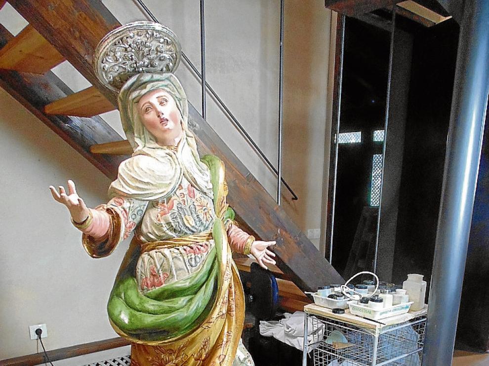 Una restauradora trabaja en la talla de Santa Ana.