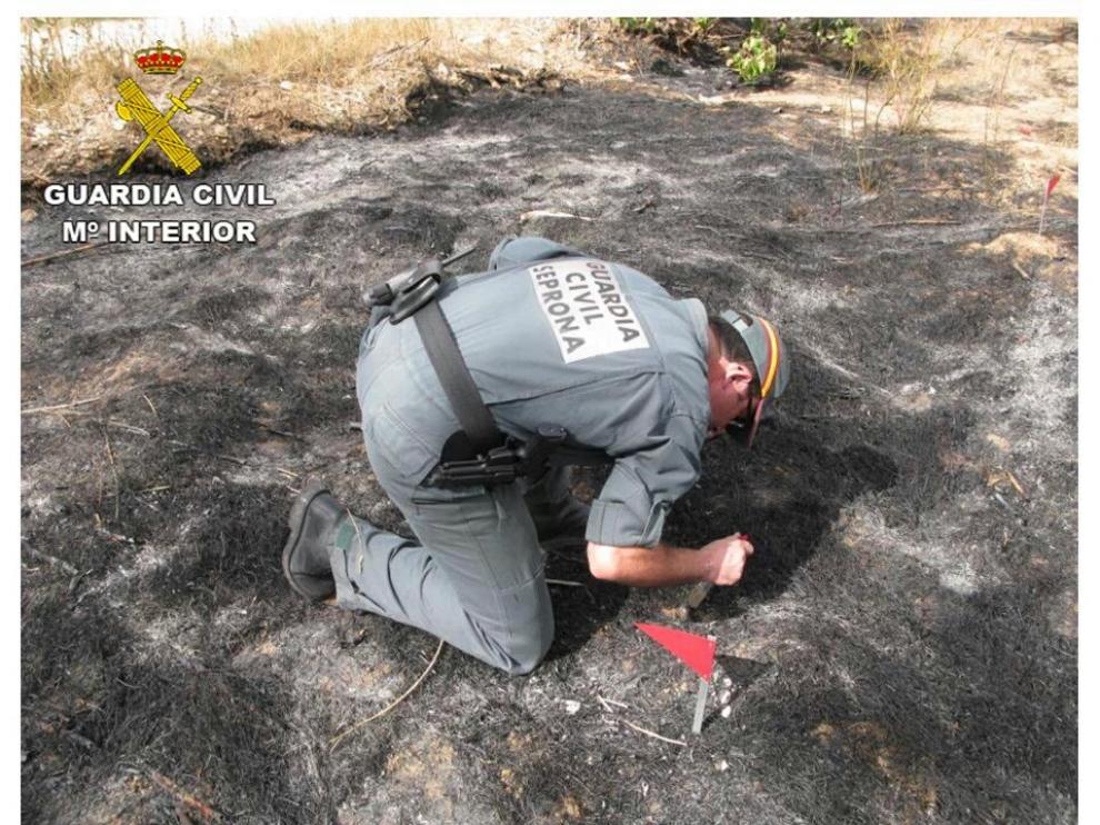 Un agente inspecciona el lugar en el que se produjo el incendio
