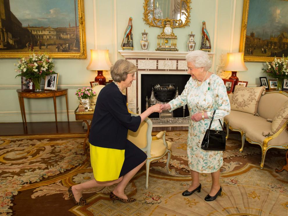Theresa May saludando a la reina Isabel II.