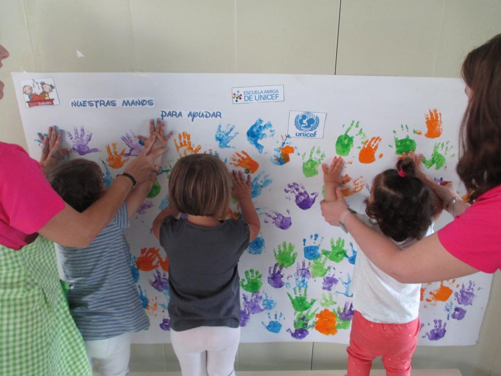 Alumnos de Infantil de la escuela de Barbastro plasman sus manos sobre el mural.