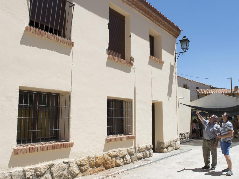 Dos vecinos de Villarroya de los Pinares observan el balcón desde el que cayó el joven.