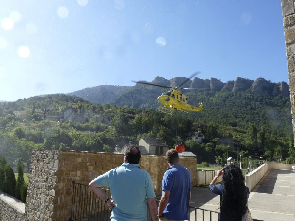 Vecinos de Santa Cruz de la Serós miran cómo los helicópteros cogen agua en las piscinas.