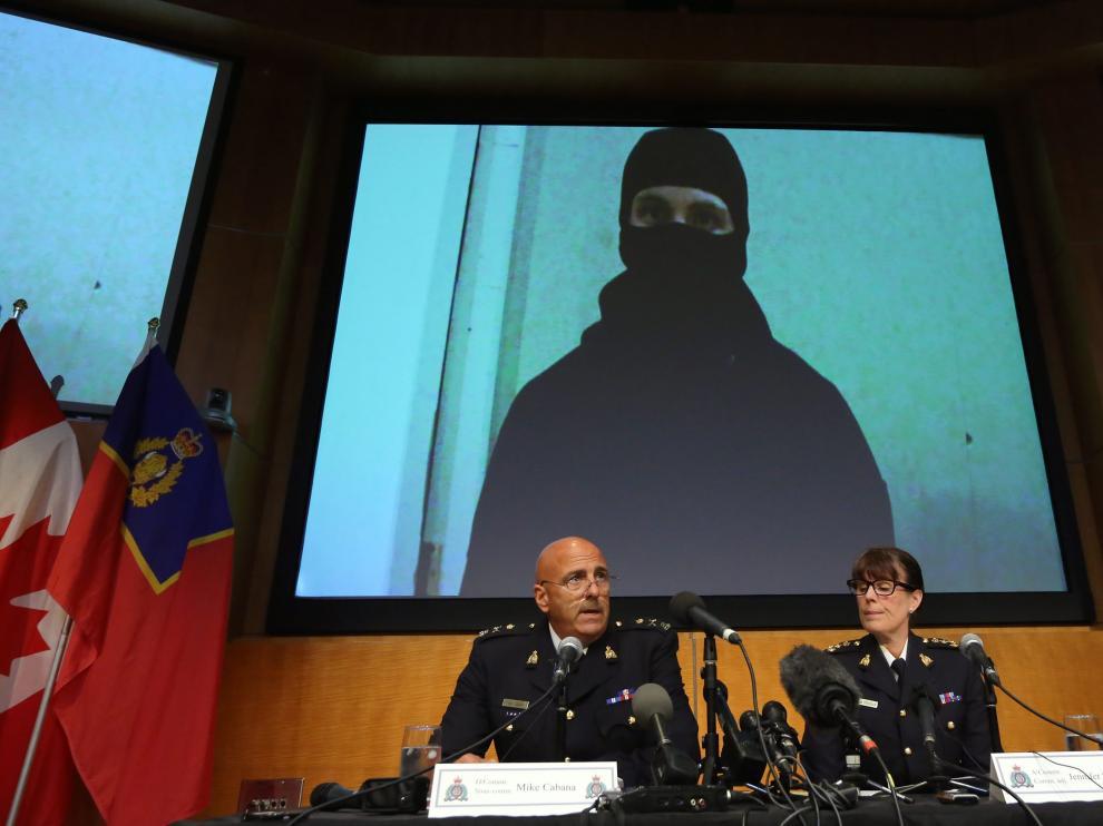 Los portavoces de la Policía Montada explican la operación con una imagen del vídeo del terrorista de fondo