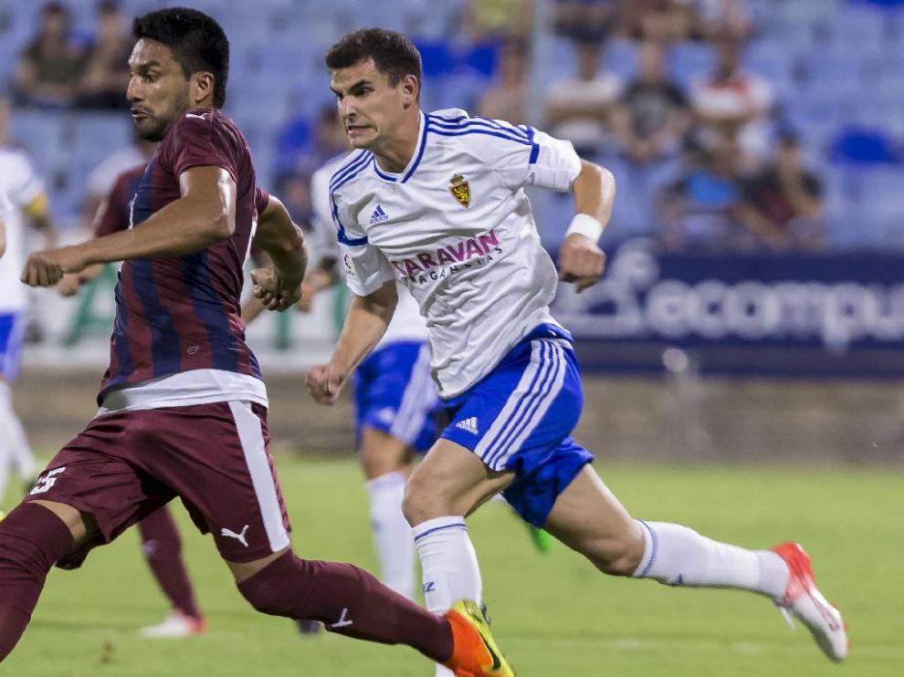 Sergio Buenacasa, en una carrera con el central Dos Santos al final del partido de este sábado en La Romareda ante el Eibar.