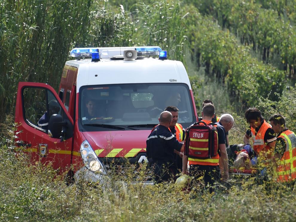 Algunos de los encargados del rescate auxilian a un pasajero del tren siniestrado.