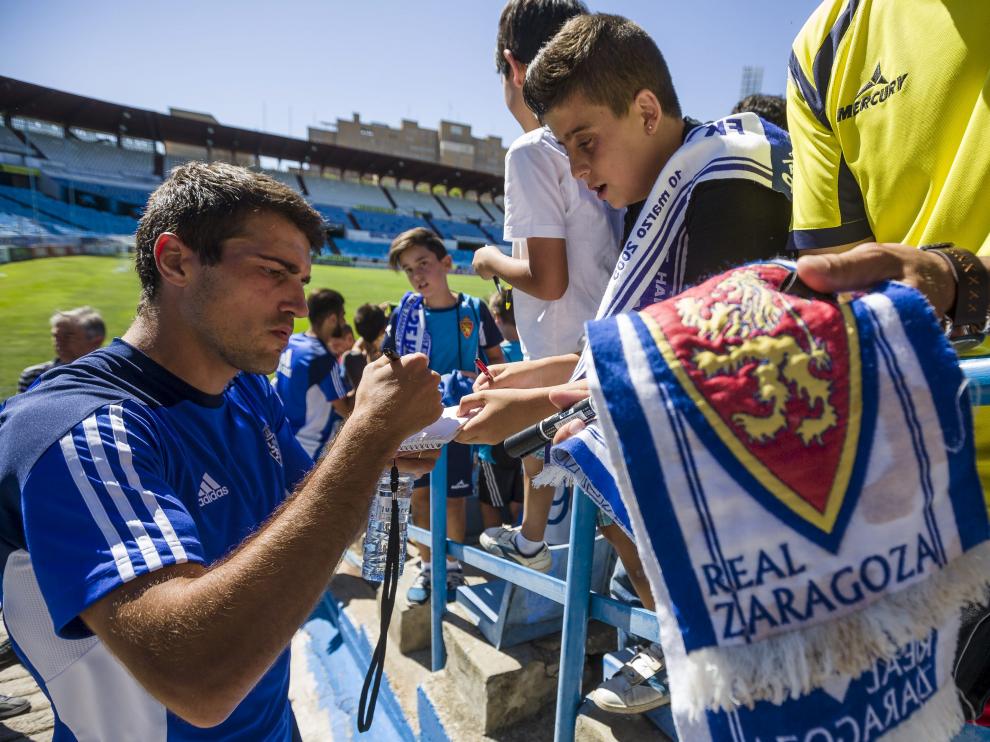 Zapater firma autógrafos a unos jóvenes seguidores zaragocistas tras un entrenamiento en La Romareda.