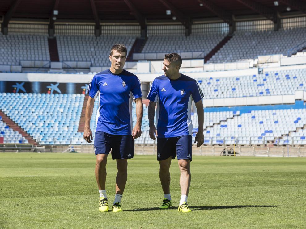Zapater y Cani, referentes del Real Zaragoza, caminando ayer sobre el césped de La Romareda.