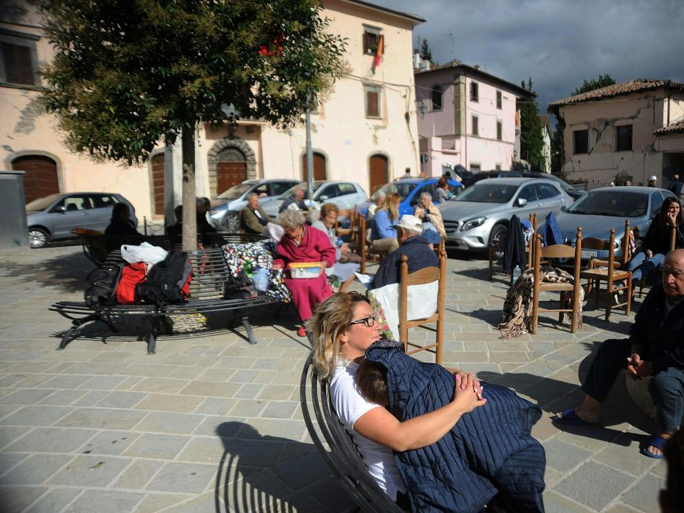 Vecinos de Accumoli sentados en una plaza tras el terremoto que ha asolado el centro de Italia.
