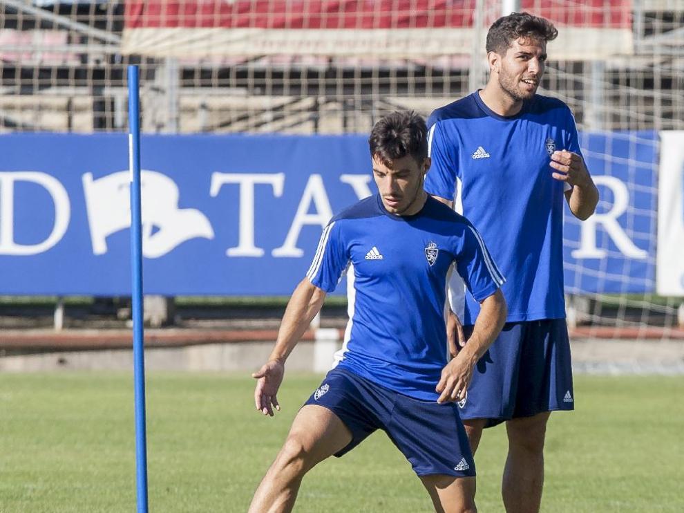Leandro Cabrera, detrás de Isaac, durante el entrenamiento del Real Zaragoza este miércoles en la Ciudad Deportiva.