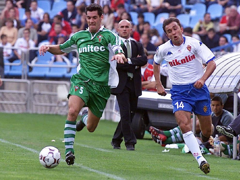 Luis César Sampedro, en segundo término delante de su banquillo en La Romareda, el 6 de octubre de 2002 en un Real Zaragoza-Racing de Ferrol. Juanele intenta desbordar al defensor gallego.