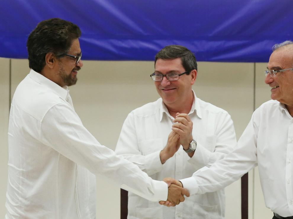El jefe negociador de las FARC, Iván Márquez, y el del Gobierno de Colombia, Humberto de la Calle, se estrechan la mano tras el acuerdo.