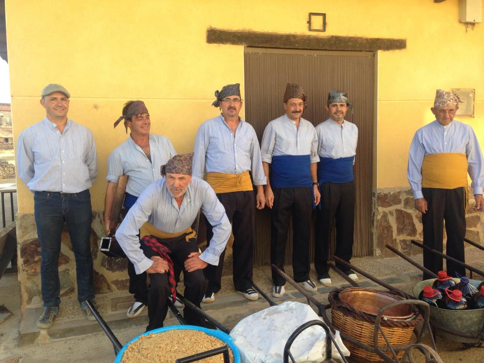 Los vecinos usaron trajes y elementos tradicionales para el reparto de las migas y el vino.