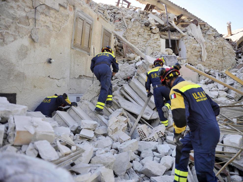 Varios bomberos trabajan entre los escombros en Pescara del Tronto