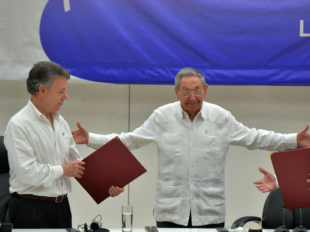 El presidente colombiano Santos (izquierda) y Timochenko (derecha), con Raúl Castro en el centro