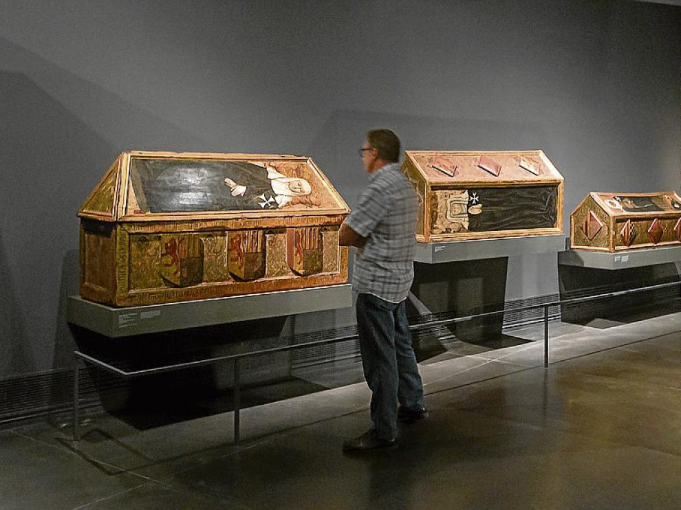 Un visitante contempla las tres cajas sepulcrales de Sijena expuestas en Lérida.