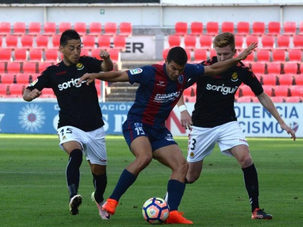 Alexander controla el balón ante la presión de Juan Delgado y Mossa