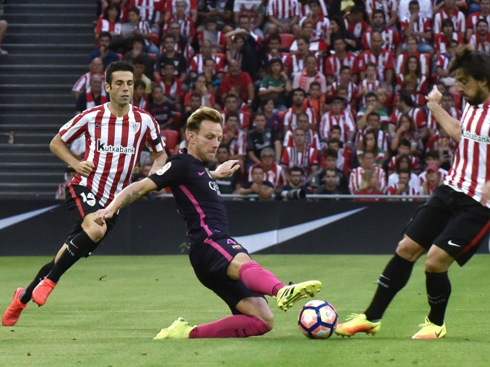 Rakitic trata de llevarse el balón ante dos contrarios