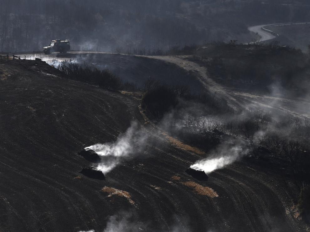 Pacas de paja aún humeantes por el incendio declarado ayer entre las localidades de Tafalla y Pueyo, en Navarra