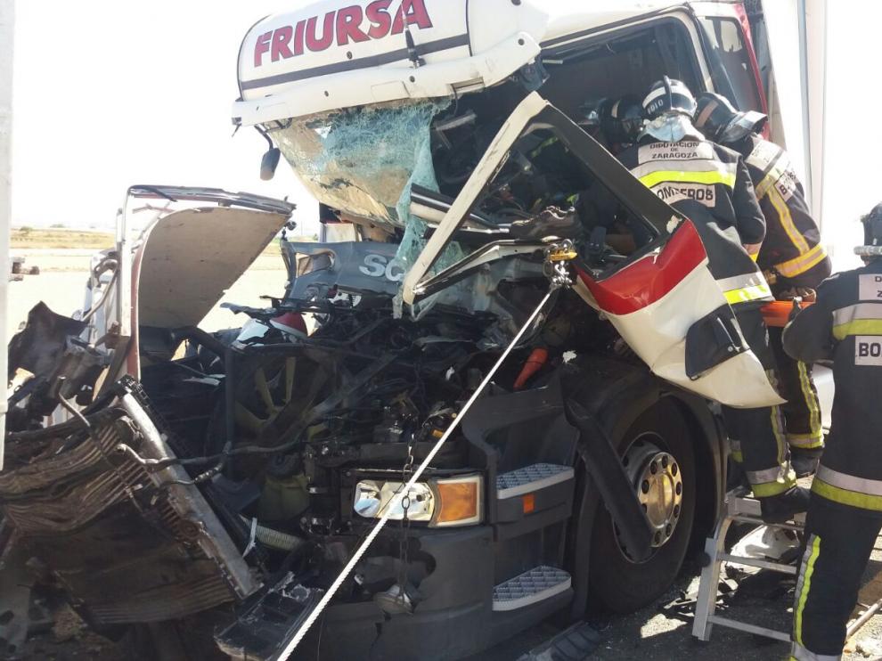Los bomberos durante la excarcelación del conductor de uno de los camiones.