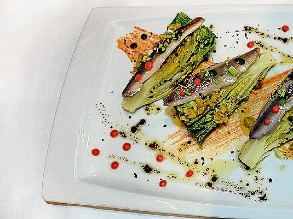 Cogollos de Tudela con boquerones, aceite de olivas negras y pimiento rojo.