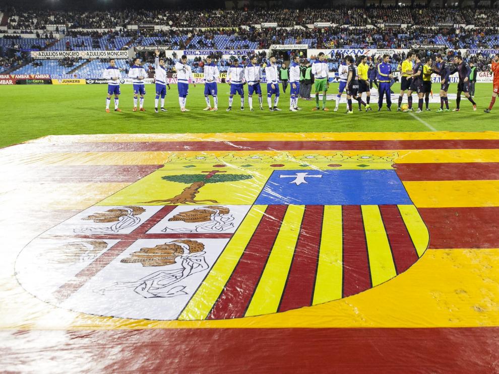 Los jugadores del Real Zaragoza y el Huesca se saludan durante el derbi de la pasada temporada