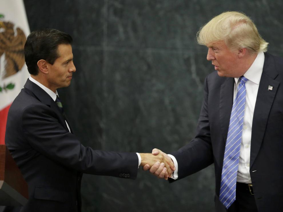 El presidente mexicano, Enrique Peña Nieto, y el candidato republicano a la Casa Blanca, Donald Trump, estrechándose la mano en una rueda de prensa hoy en Ciudad de México.