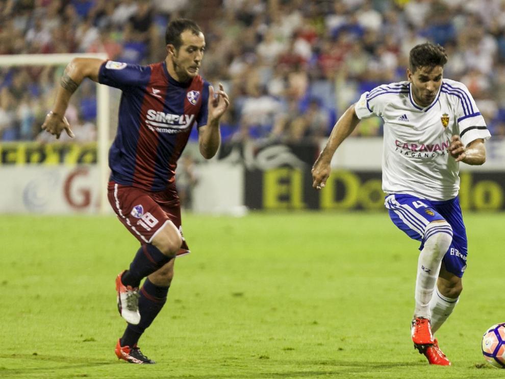 Cabrera, corta un balón ante Urko Vera durante el partido ante el Huesca, donde cayó lesionado con un esguince de tobillo.
