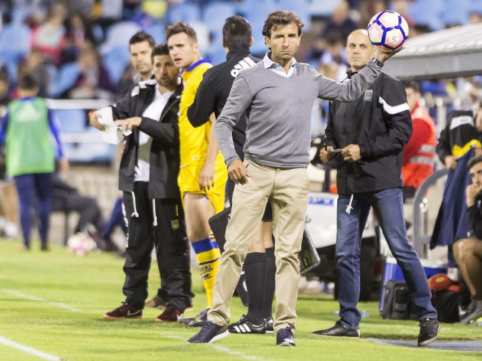 Luis Milla, recoge un balón en su banquillo durante el transcurso del Real Zaragoza-Alcorcón del pasado sábado.