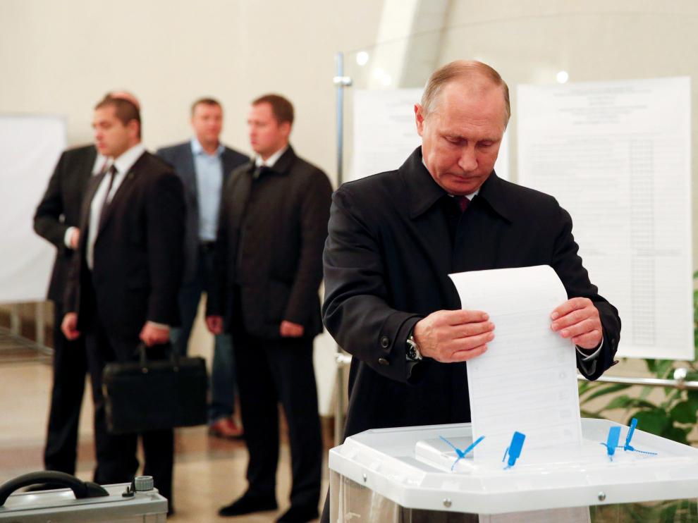 Putin introduce con gesto serio una papeleta asabanada