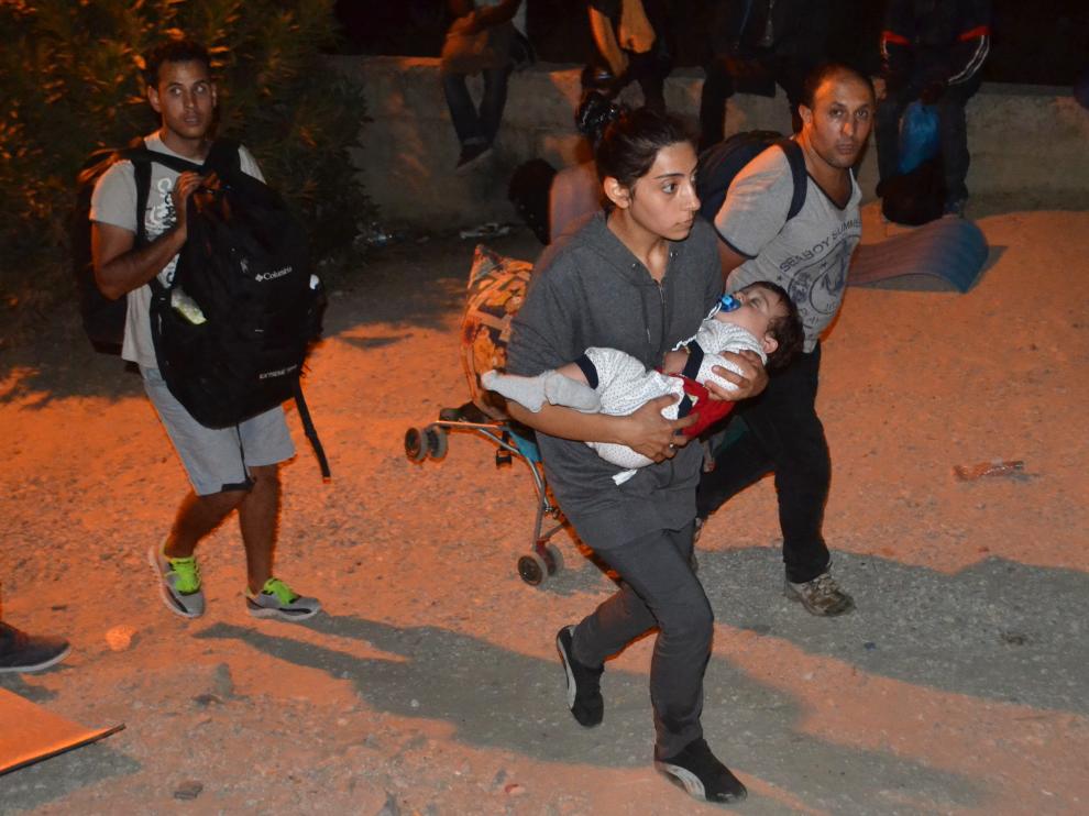 Varios refugiados huyen del fuego en el campo de Moria.