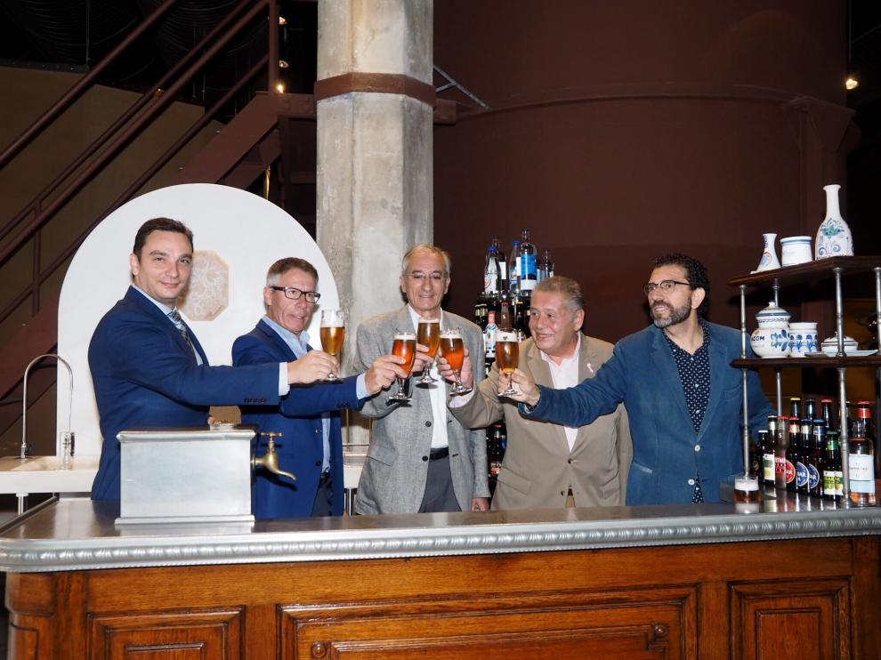 Pedro Giménez, presidente de la Asociación de Cafés y Bares, y José Luis Ansó, presidente de la AECC en Zaragoza, muestran el cartel del Concurso de Tapas con el lazo rosa que simboliza la lucha contra el cáncer de mama.
