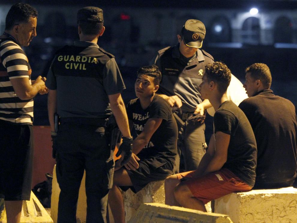 Efectivos de la Guardia Civil junto a algunos de los inmigrantes rescatados cerca de Tarifa.