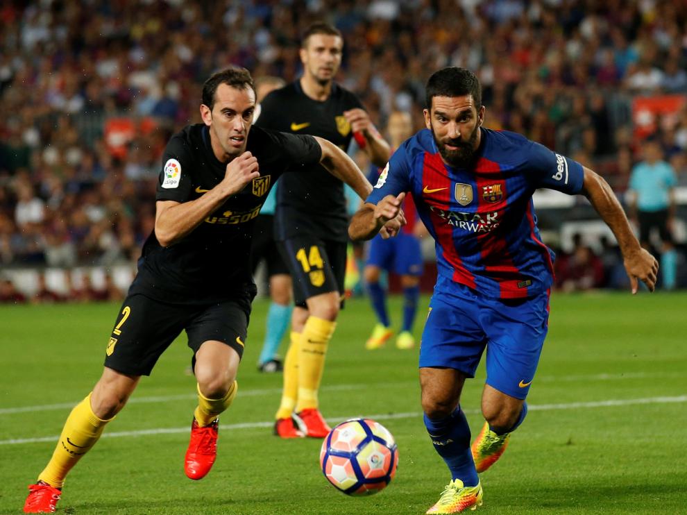 Arda Turán disputa la posesión con Diego Godín.