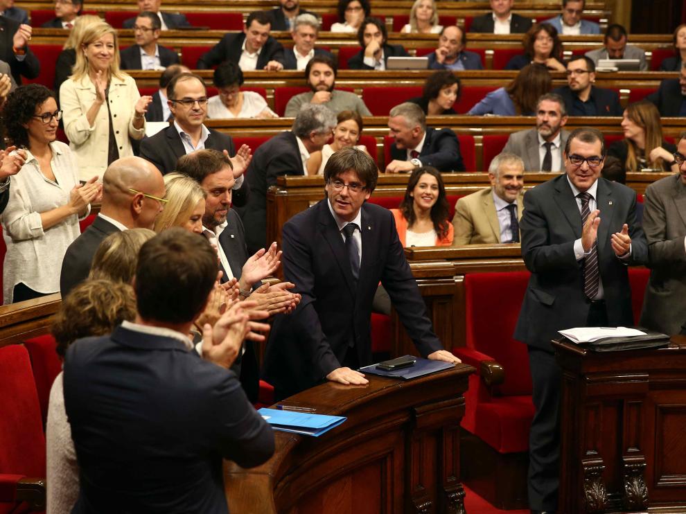El presidente de la Generalitat, Carles Puigdemont, recibe el aplauso de sus compañeros tras su intervención en el debate de cuestión de confianza
