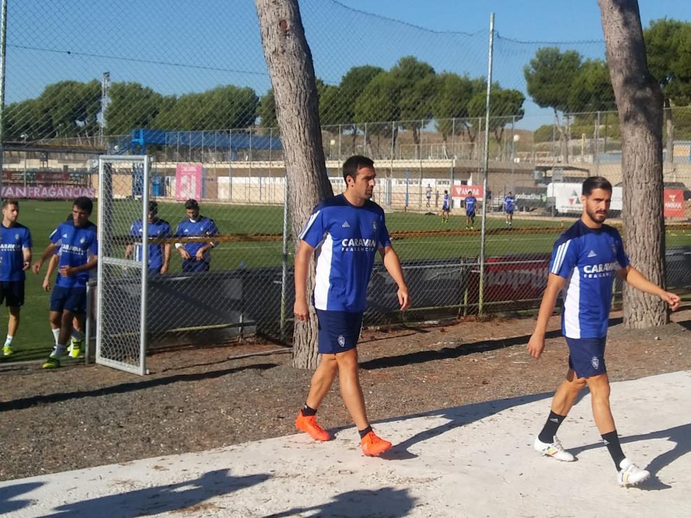 José Enrique, detrás de Javi Ros, camina hacia la sala de vídeo de la Ciudad Deportiva antes del entrenamiento de este jueves.