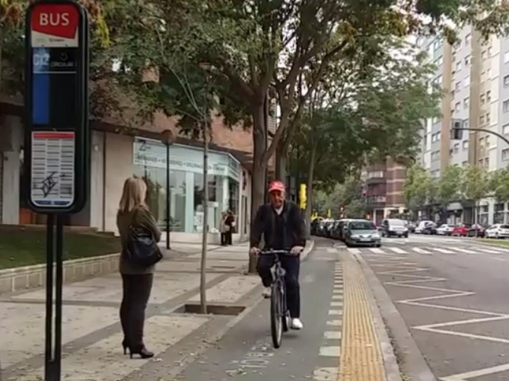Un carril bici unidireccional atraviesa una parada de autobús.