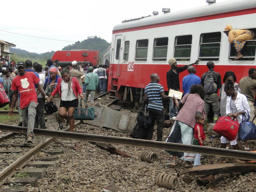 Algunos pasajeros salen del tren siniestrado.