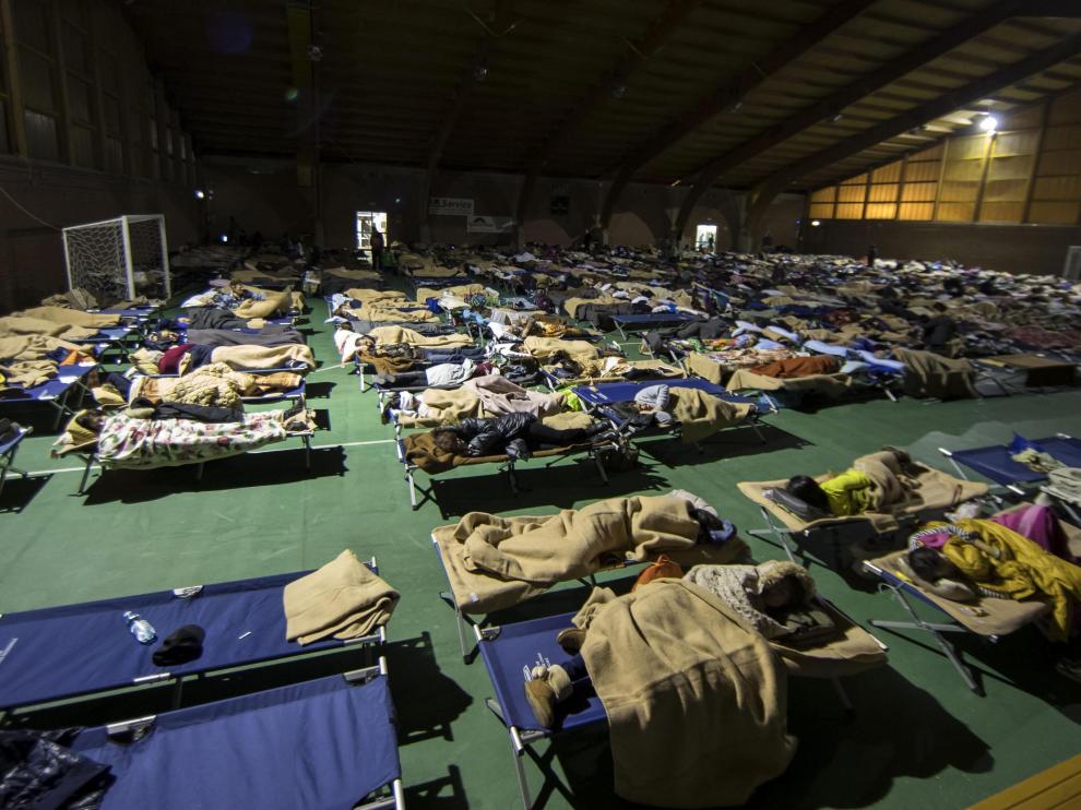 Varios residentes duermen en un pabellón deportivo reconvertido en albergue temporal en la ciudad de Camerino.