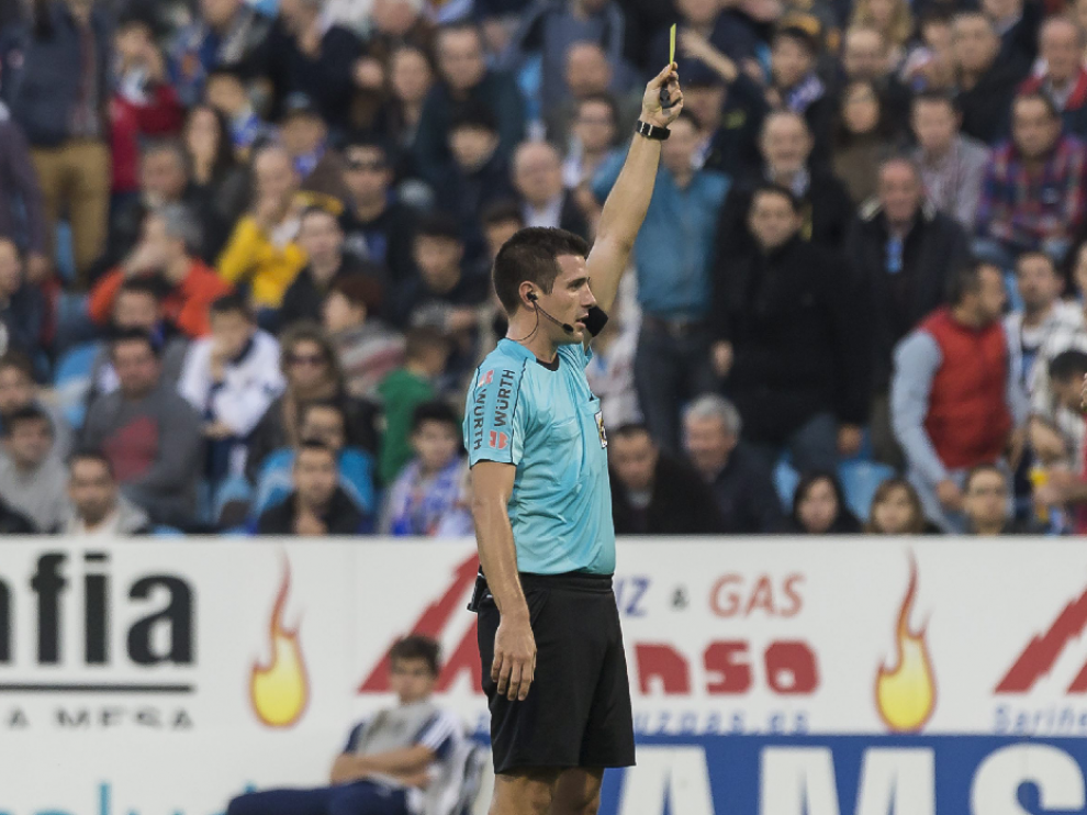Díaz de Mera, el árbitro del pasado sábado en el partido frente al Almería, muestra una tarjeta amarilla. Él señaló el quinto penalti en contra del Real Zaragoza en las 12 primeras jornadas de liga.
